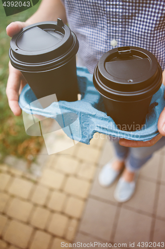 Image of Crop person holding coffee cups