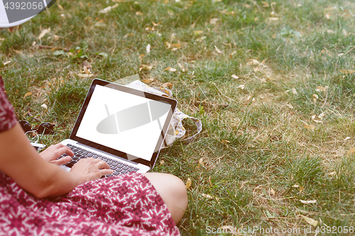 Image of Crop top view of woman using laptop