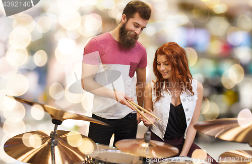 Image of man and woman with drum kit at music store