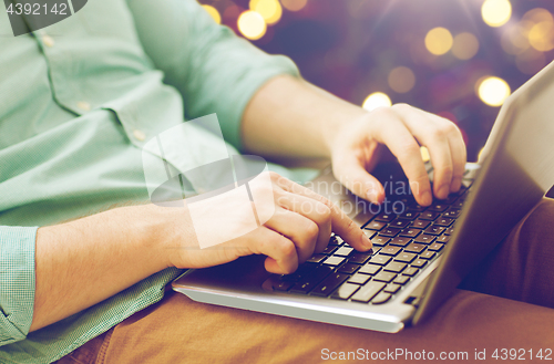 Image of close up of man typing on laptop keyboard