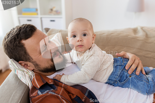 Image of happy father with little baby boy at home