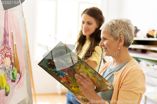 Image of happy women painting at art school studio