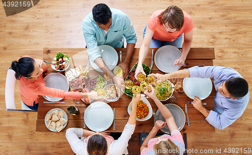 Image of people having dinner and clinking wine glasses