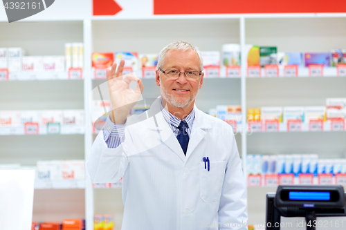 Image of senior apothecary at pharmacy showing ok hand sign