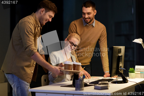 Image of business team with computer working late at office