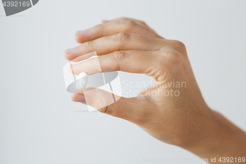 Image of close up of hand holding medicine pill