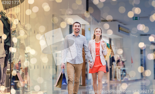 Image of happy young couple with shopping bags in mall