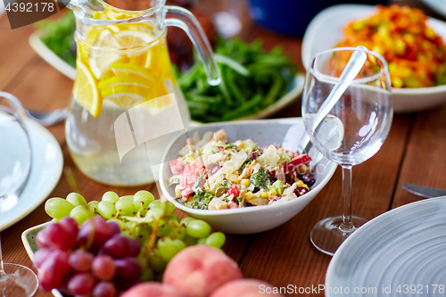 Image of vegetable salad in bowl and other food on table