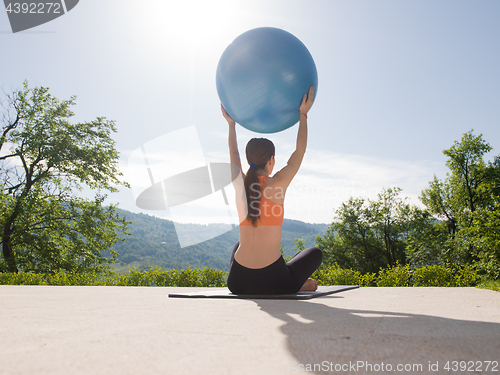 Image of woman doing exercise with pilates ball