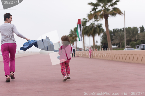 Image of mother and cute little girl on the promenade by the sea