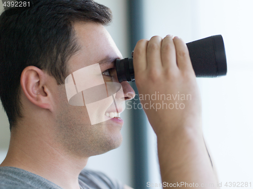 Image of man looking with binoculars