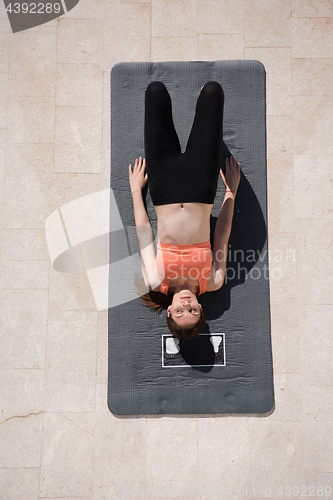 Image of woman doing morning yoga exercises top view