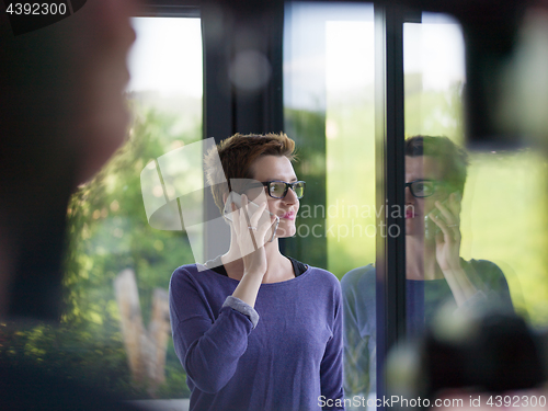 Image of young women using mobile phone by the window