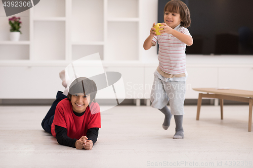 Image of boys having fun with an apple on the floor