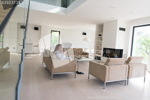 Image of young woman in a bathrobe enjoying morning coffee