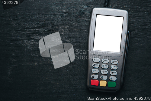 Image of Credit card terminal on dark wooden desk