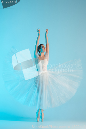 Image of Young and incredibly beautiful ballerina is dancing in a blue studio