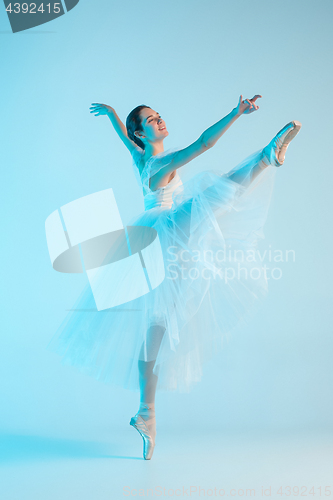 Image of Young and incredibly beautiful ballerina is dancing in a blue studio