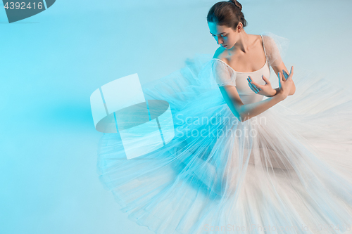 Image of Young and incredibly beautiful ballerina is dancing in a blue studio