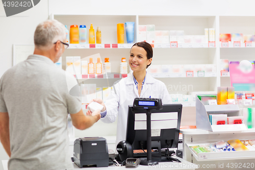 Image of apothecary selling drug to senior man at pharmacy