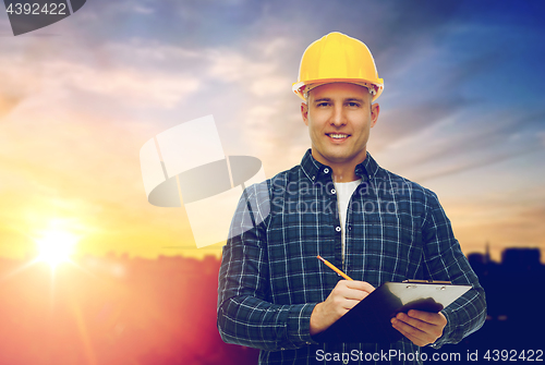 Image of male builder in yellow hard hat with clipboard