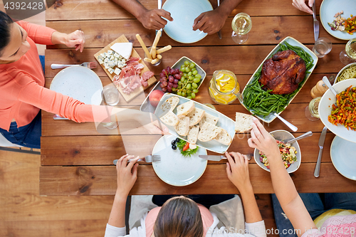 Image of group of people eating at table with food