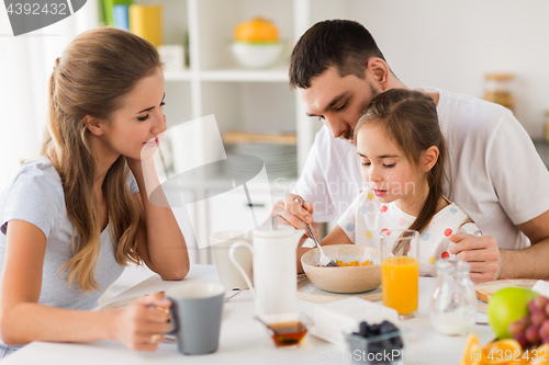 Image of happy family having breakfast at home
