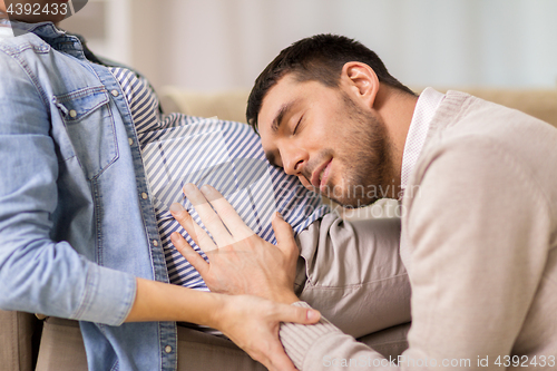 Image of happy man with pregnant woman at home