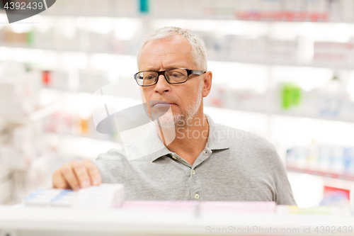 Image of senior male customer with drug at pharmacy