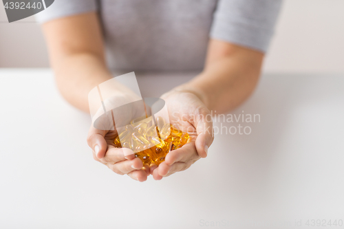 Image of hands holding cod liver oil capsules