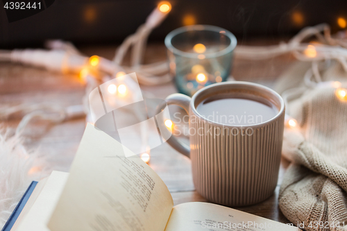 Image of book and cup of coffee or hot chocolate on table