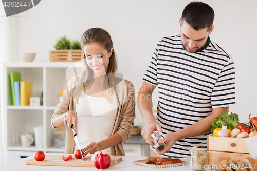 Image of happy couple cooking food at home kitchen