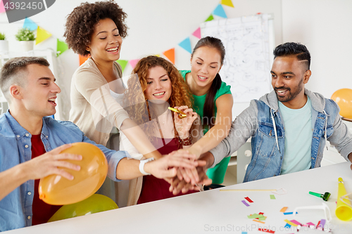 Image of happy business team at office party holding hands