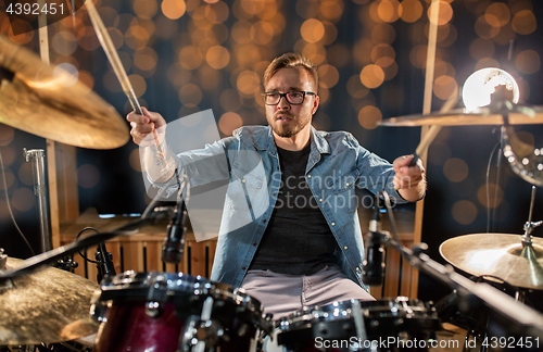 Image of musician or drummer playing drum kit at concert