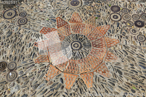 Image of Patterned floor with pattern from pebbles bricks and gears