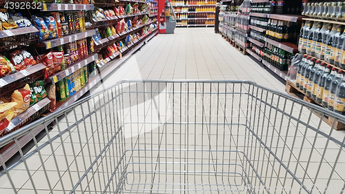 Image of Shopping cart in supermarket aisle