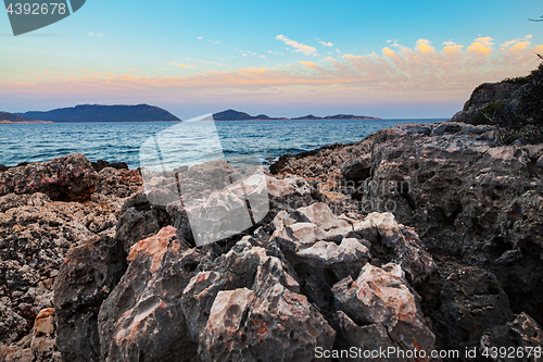 Image of Sunset over rough volcanic rock coastline landscape