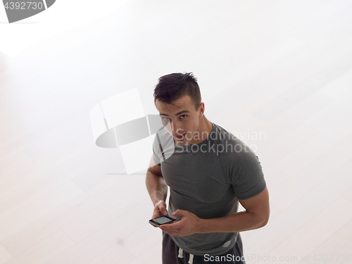 Image of young man using a mobile phone  at home