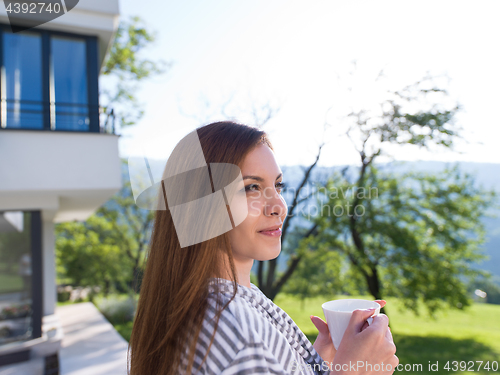 Image of woman in a bathrobe enjoying morning coffee
