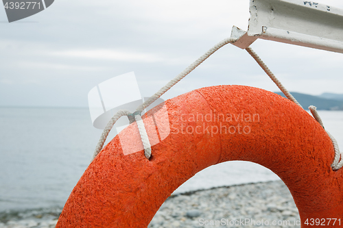 Image of orange lifebuoy on the sea coast