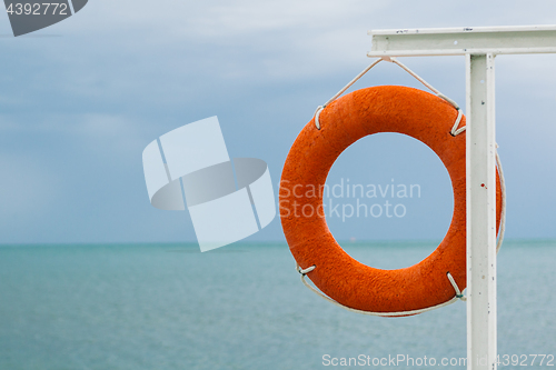 Image of orange lifebuoy on the sea coast