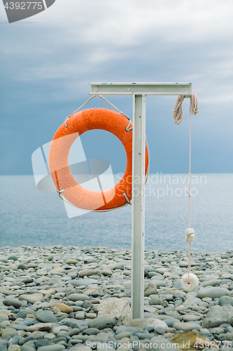 Image of orange lifebuoy on the sea coast