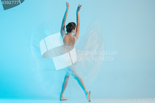 Image of Young and incredibly beautiful ballerina is dancing in a blue studio