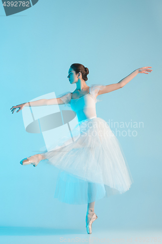 Image of Young and incredibly beautiful ballerina is dancing in a blue studio