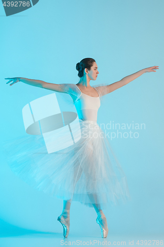 Image of Young and incredibly beautiful ballerina is dancing in a blue studio