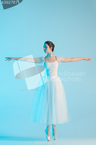 Image of Young and incredibly beautiful ballerina is dancing in a blue studio