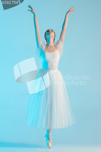 Image of Young and incredibly beautiful ballerina is dancing in a blue studio