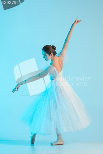 Image of Young and incredibly beautiful ballerina is dancing in a blue studio