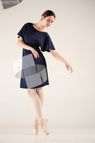 Image of Young and incredibly beautiful ballerina is dancing in a blue studio