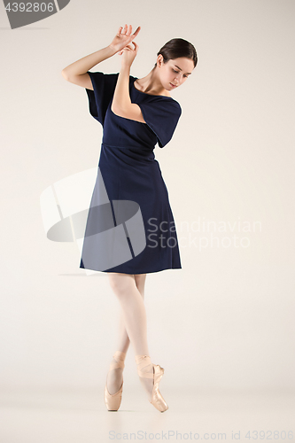 Image of Young and incredibly beautiful ballerina is dancing in a blue studio